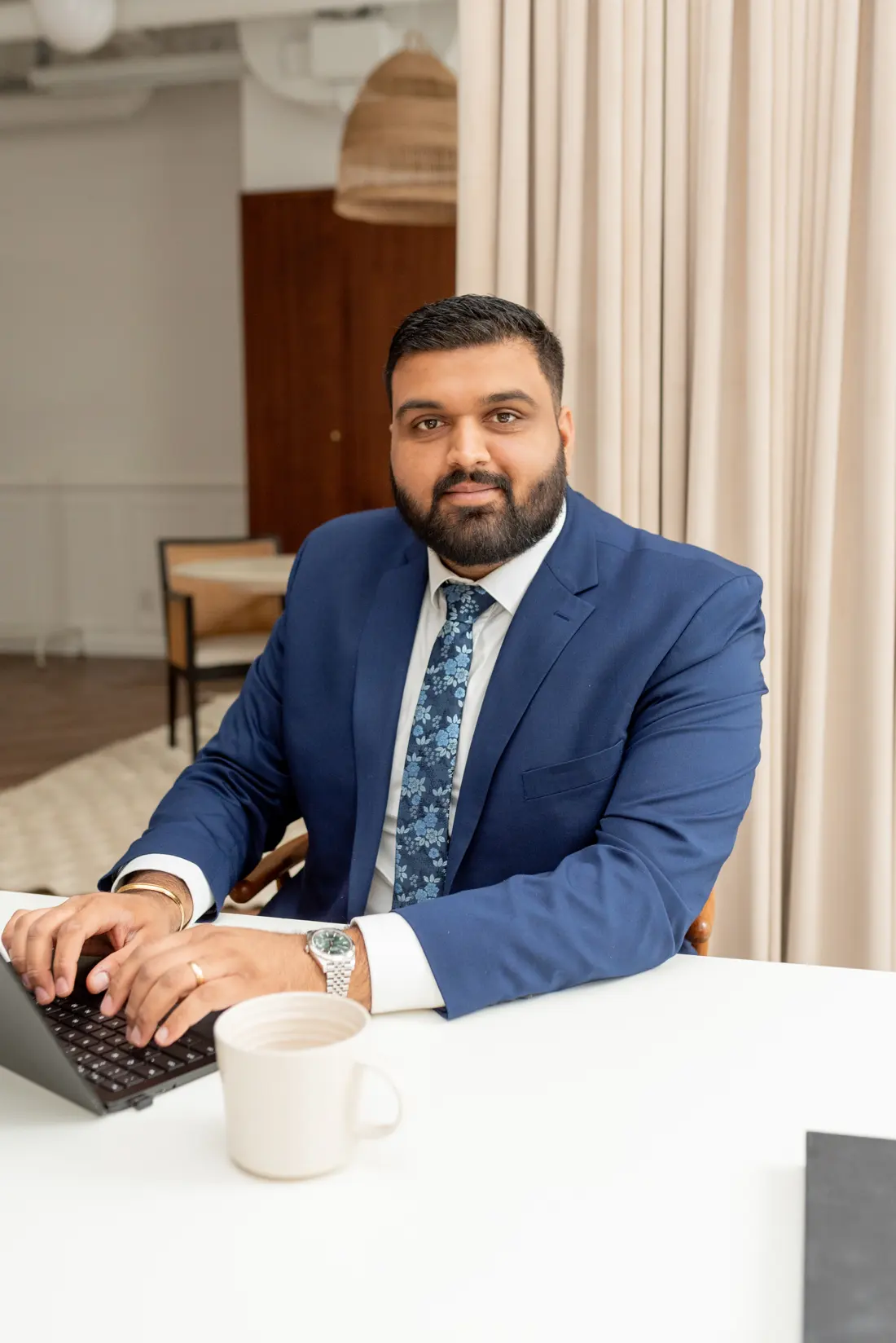 Puneet Mann at his desk, looking up from his laptop